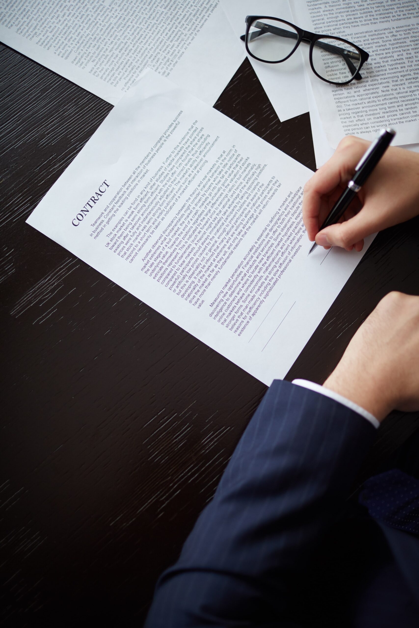 Torts Compensation Services - Close-up of businessman holding pen during legal consultation